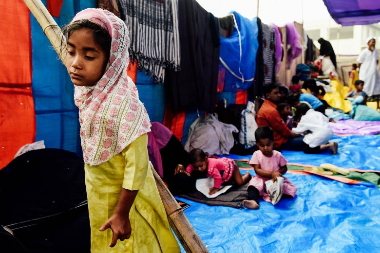 A Rohingya refugee girl looks on at a temporary shelter in New Delhi on Monday, following a fire that broke out at their camp early Sunday that left about 200 people homeless.